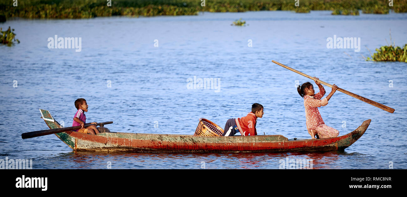 Tonlé Sap Lago, Cambogia. Xviii Dicembre, 2017. Tre bambini fila la loro imbarcazione in legno e giocare. Foto: Bryan Watt Foto Stock