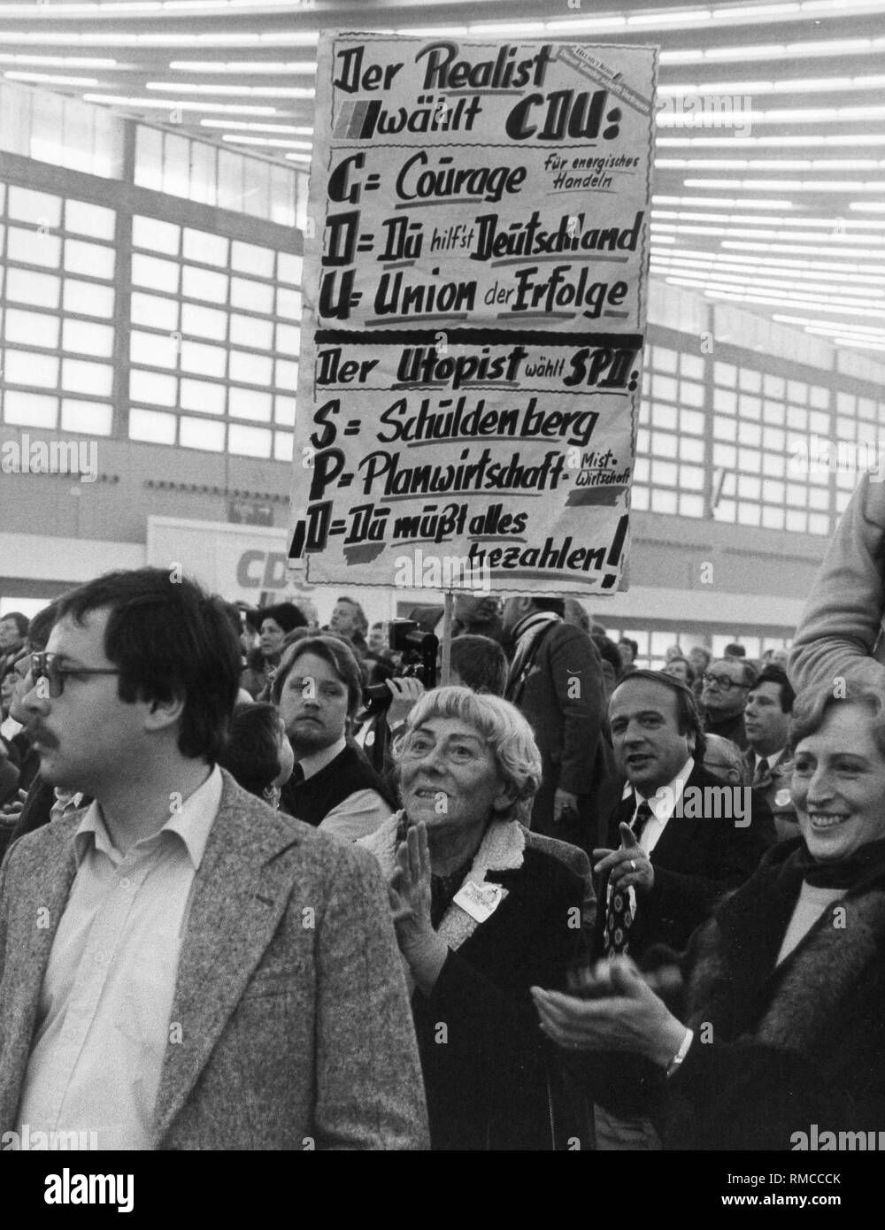 In corrispondenza di un evento di campagna dell'Unione, partito sostenitori portano un poster "Il realista sceglie CDU - il Utopist sceglie SPD'. Foto Stock