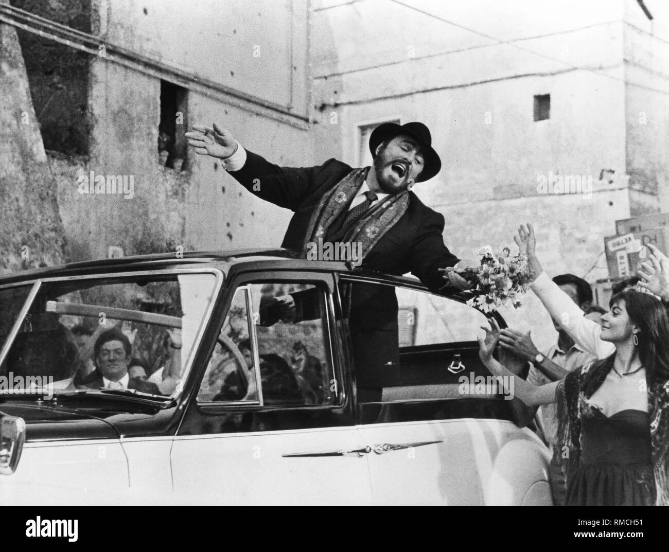 Luciano Pavarotti, un'opera italiana cantante, svolge un cantante di opera nel suo primo film "Sì giorgio'. Qui egli è il cantare in un convertibile e ammirato dai fan femminili. Foto Stock