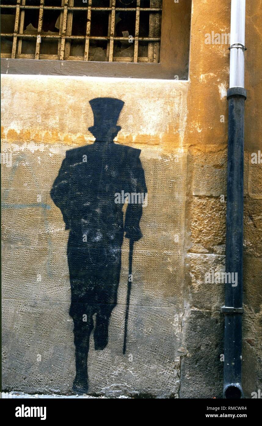 Graffito con l'ombra di un uomo che corre con cappello a cilindro e bastone  Foto stock - Alamy