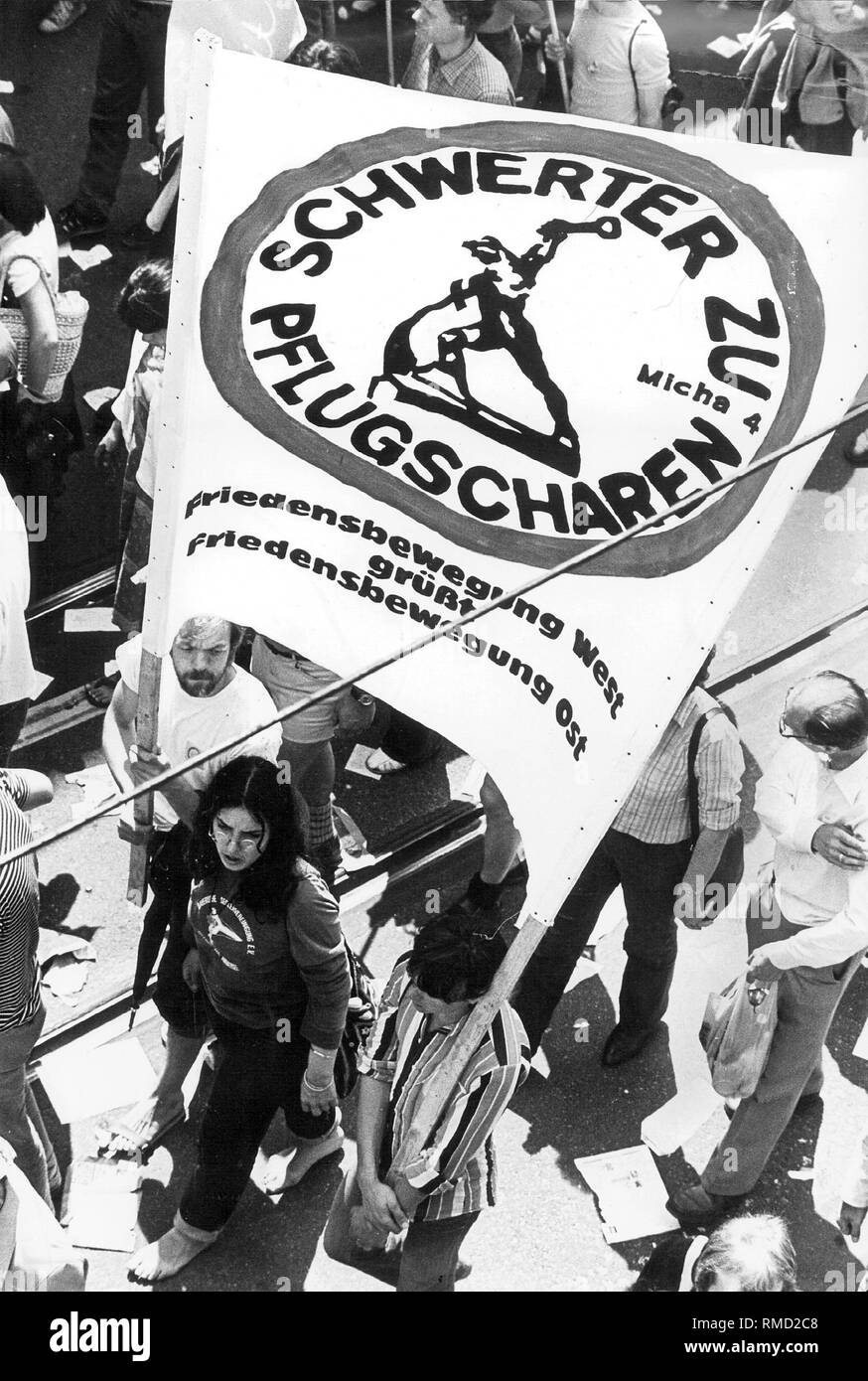 I manifestanti in una dimostrazione di pace in occasione della riunione della NATO a Bonn trasportare un poster con la scritta "parole di vomeri - il movimento per la pace in West saluta il movimento per la pace in oriente". Foto Stock