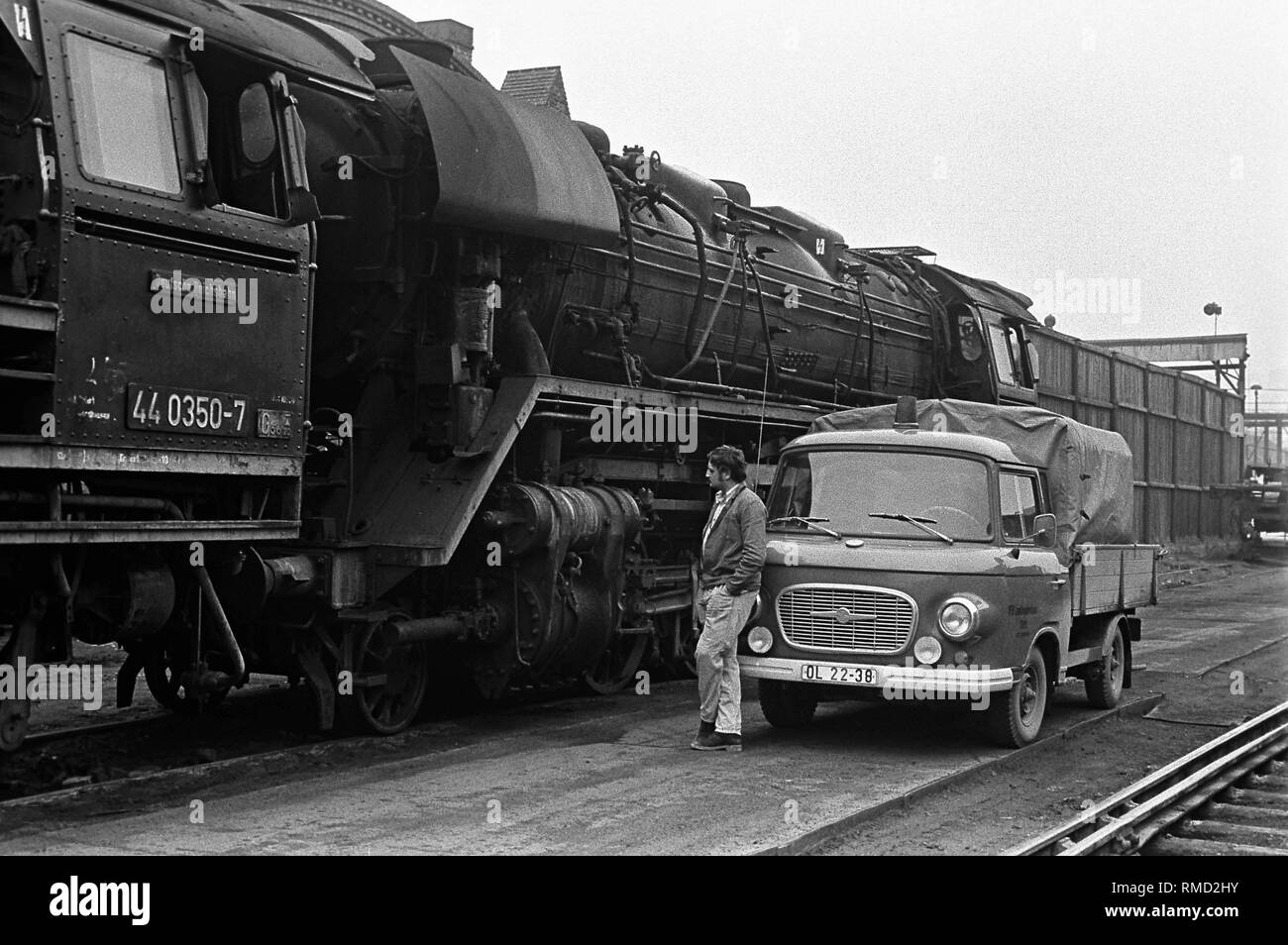 Un lavoratore si trova di fronte a una 'Barkas' pick-up nella parte anteriore di una locomotiva in materie (Reichsbahn-Ausbesserungswerk) (Reichsbahn repair shop). Foto Stock