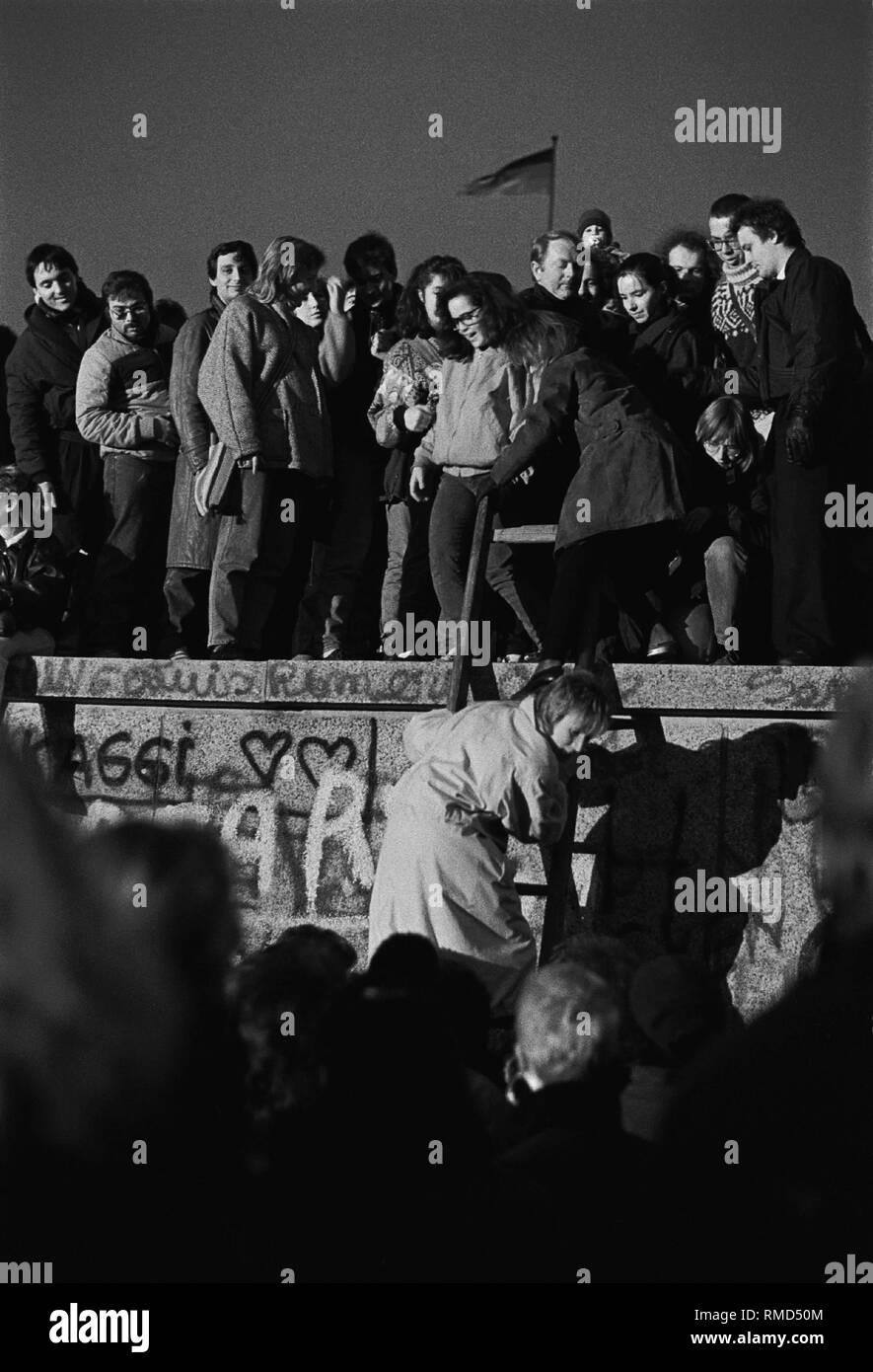 Gioiosa festa a muro alla porta di Brandeburgo, persone provenienti da Oriente e Occidente sono in piedi sul muro, alcuni sono salendo verso l'alto (Berlino Ovest lato), Berlin-Tiergarten, 10.11. 1989 Foto Stock