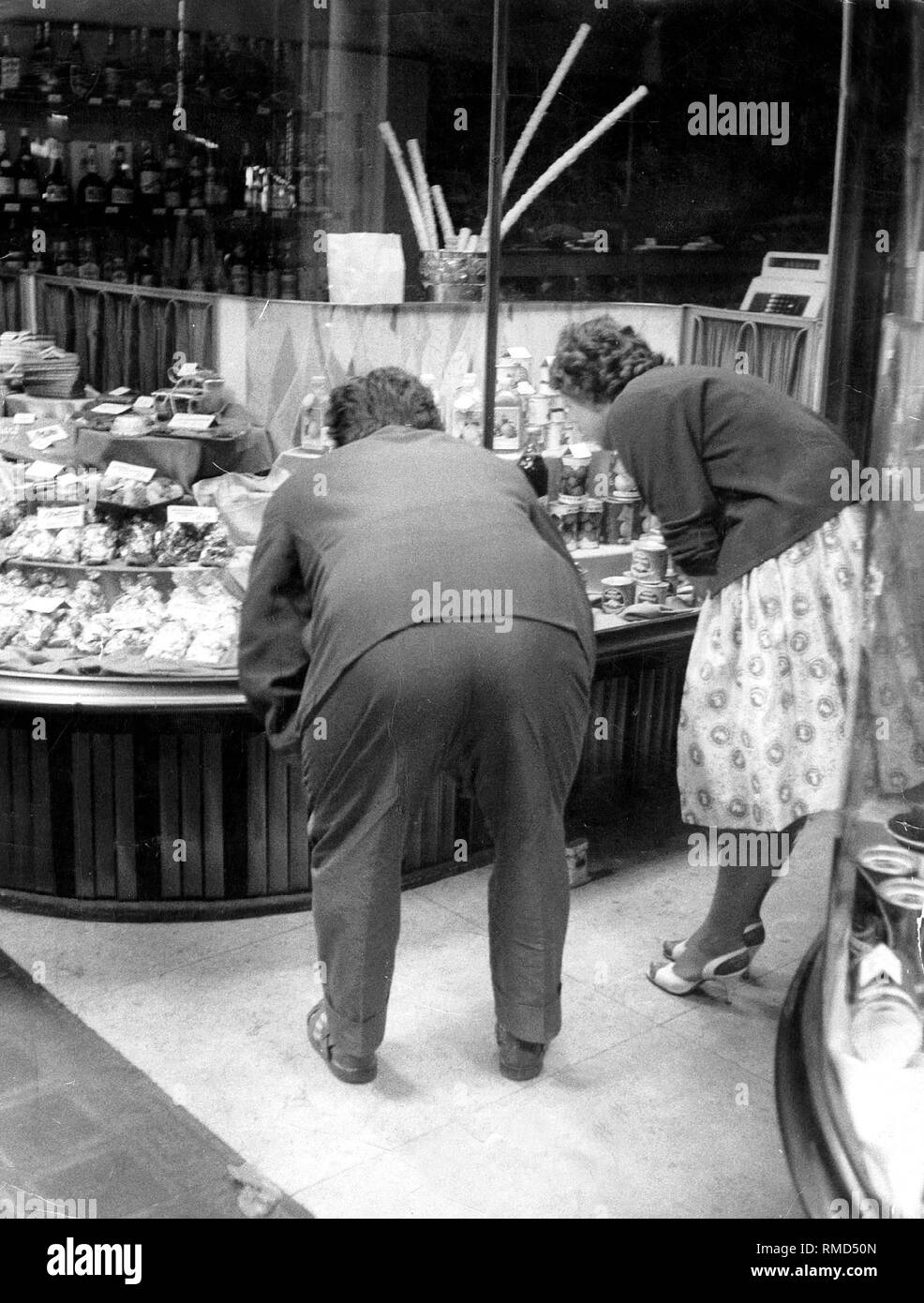 Un giovane guarda il display di un deli. Foto Stock