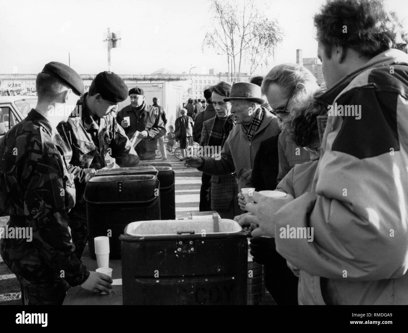 Dopo la caduta del muro di Berlino, i soldati dell'Esercito britannico fornire bevande a Oriente i berlinesi che sono in visita a Berlino Ovest, poiché la valuta estera è costoso. Foto Stock