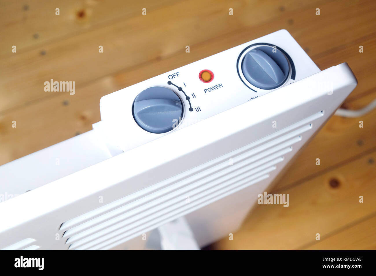 Lavoro elettrico bianco termoconvettore con il pannello di controllo sulla parte superiore su pavimento di legno in una stanza della casa vista superiore closeup Foto Stock