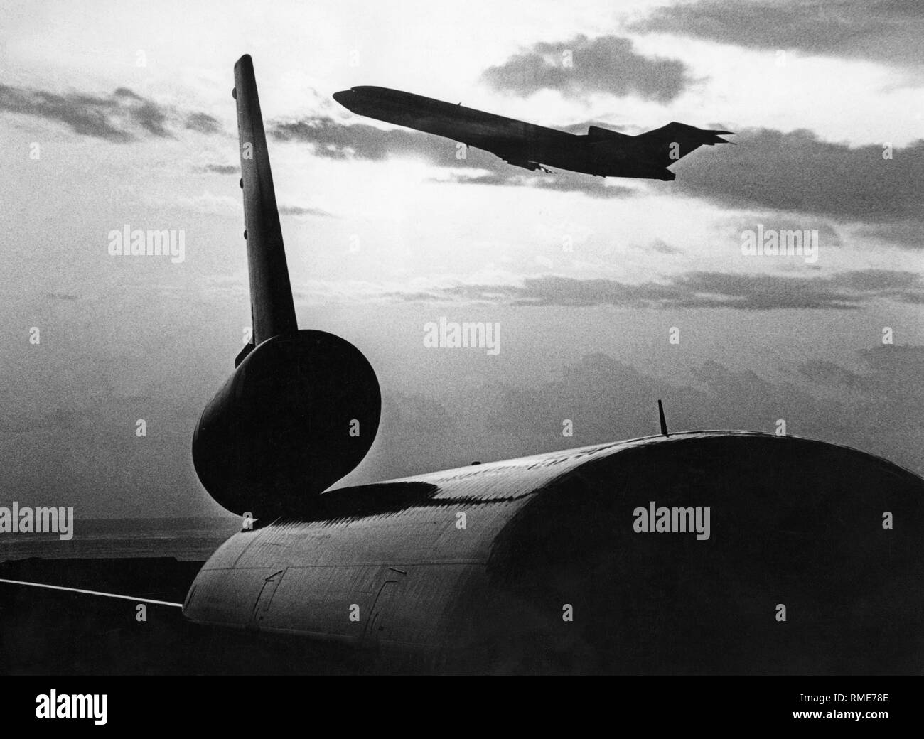 Un Boeing 727 in decollo. In primo piano un McDonnell Douglas MD-11 con una caratteristica il terzo motore nel piano verticale di coda. Foto Stock
