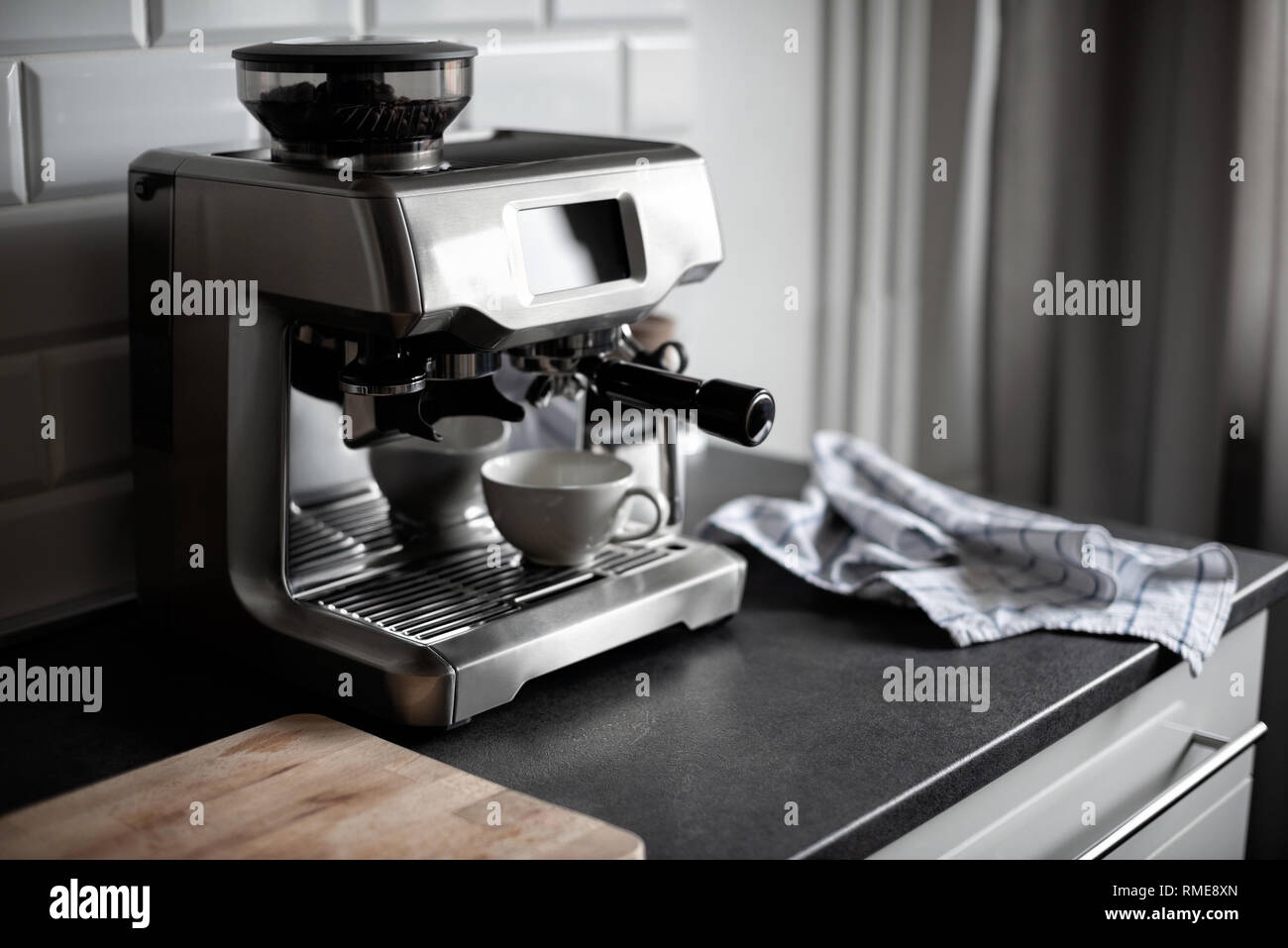 Una combinazione di una moderna e classica macchina da caffè con touch screen e portafilter moderno in bianco e nero in cucina. Messa a fuoco selettiva. Foto Stock
