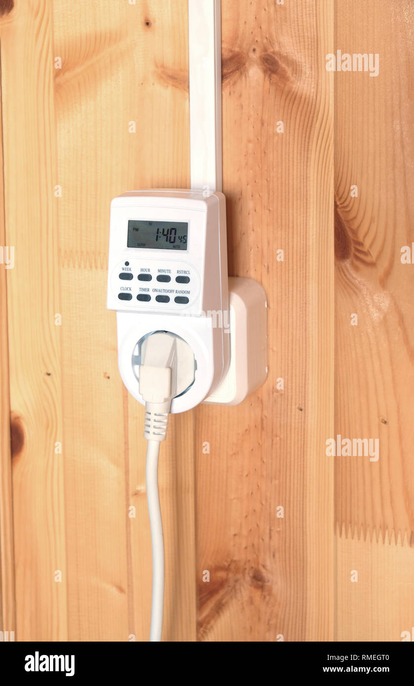 Lavoro elettrico bianco timer spina presa azionati casa intelligente sistema contro la parete di legno all'interno camera vista laterale vista dettagliata Foto Stock