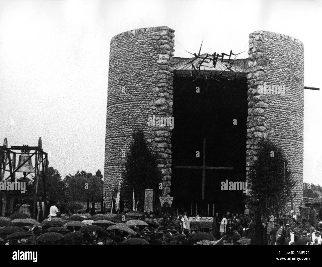 Il 'Giorno della croce' presso il XXXVII Congresso Eucaristico Internazionale di Monaco di Baviera per motivi (l'asse centrale del campo di strada) del campo di concentramento di Dachau ha avuto luogo la cerimonia di inaugurazione della prima spirituale sito memoriale, la "Chiesa dell'agonia mortale di Cristo " (architetto: Josef Wiedemann) in presenza di circa 50.000 persone. La manifestazione è stata preceduta da un pellegrinaggio della Gioventù Cattolica dal monaco di baviera tendopoli a Dachau. Sulla sinistra è una struttura permanente in cui un 3000kg campana fu appeso. Foto Stock