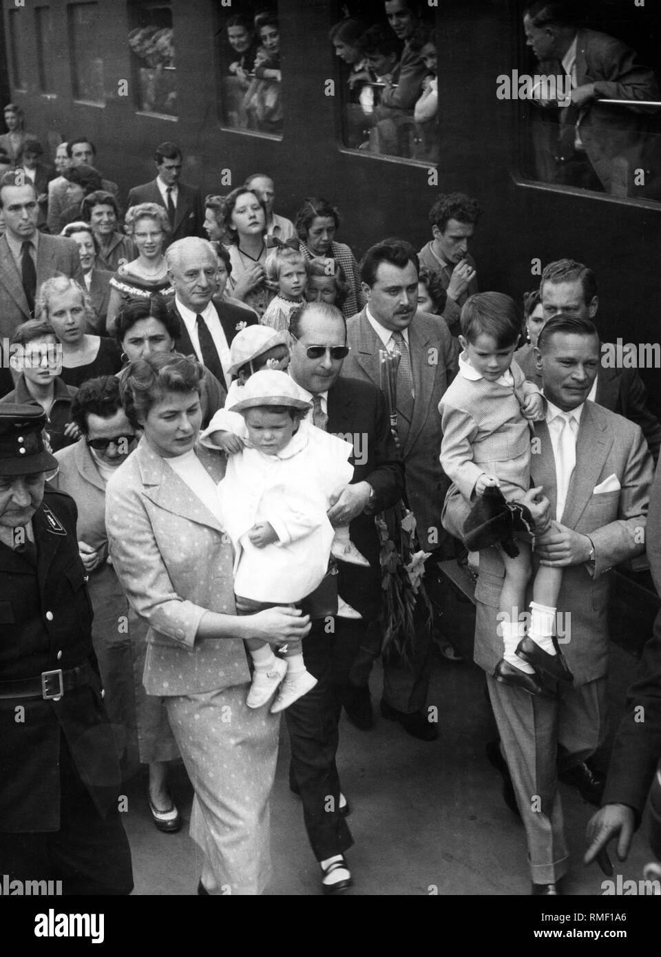 Presso la Stazione Centrale di Monaco Roberto Rosselini (con gli occhiali da sole) e Ingrid Bergman fanno la loro strada attraverso la folla, che ha riunito per salutare Bergman. Ingrid Bergman visite di Monaco di Baviera per la prima volta dal 1938. Foto Stock
