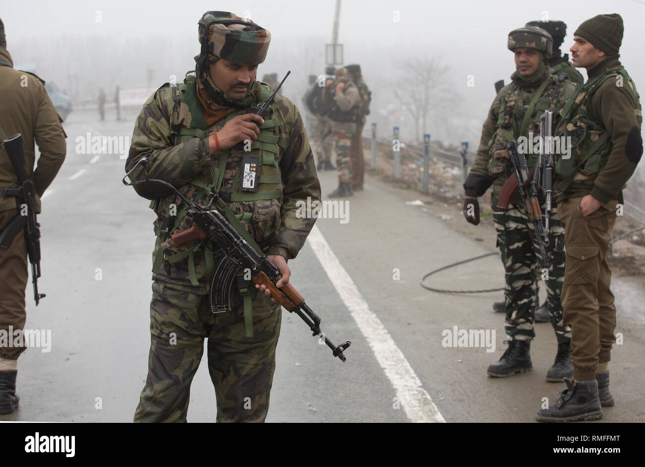 (190215) -- SRINAGAR, Feb 15, 2019 (Xinhua) -- esercito indiano e di paramilitari troopers guardia come la sicurezza e il team legale di ispezionare il relitto di veicoli presso il sito di un attacco suicida su una autostrada nazionale Lethpora vicino villaggio nel distretto di Pulwama, circa 27 km a sud di Srinagar city, la capitale estiva di Indiano-Kashmir controllata, Feb 15, 2019. Il numero di vittime di un attacco suicida di targeting di paramilitari troopers appartenenti alla riserva centrale forza di polizia (CRPF) in irrequieta indiano-Kashmir controllato il giovedì è salito a 40, hanno detto i funzionari. (Xinhua/Javed Dar) Foto Stock