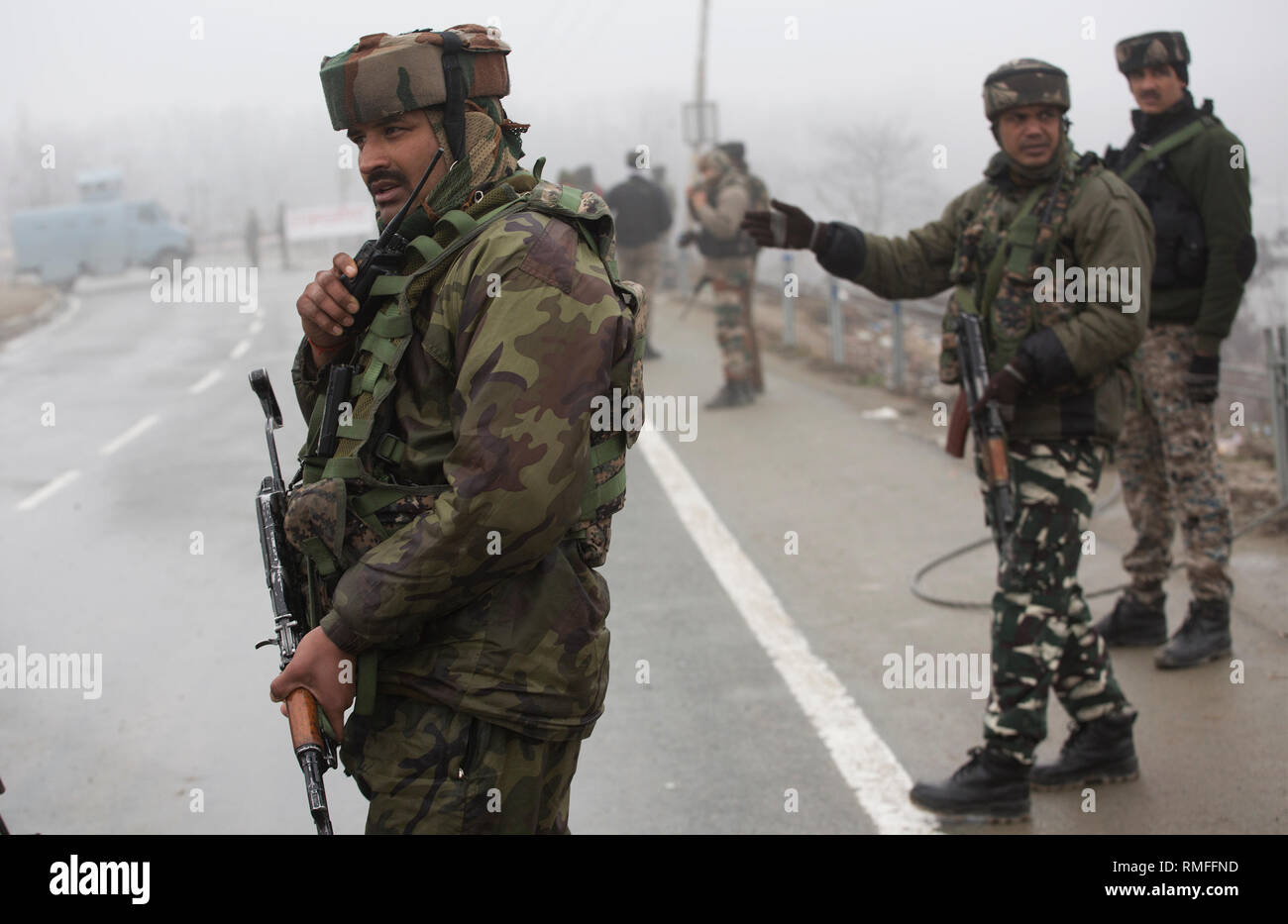 (190215) -- SRINAGAR, Feb 15, 2019 (Xinhua) -- esercito indiano e di paramilitari troopers guardia come la sicurezza e il team legale di ispezionare il relitto di veicoli presso il sito di un attacco suicida su una autostrada nazionale Lethpora vicino villaggio nel distretto di Pulwama, circa 27 km a sud di Srinagar city, la capitale estiva di Indiano-Kashmir controllata, Feb 15, 2019. Il numero di vittime di un attacco suicida di targeting di paramilitari troopers appartenenti alla riserva centrale forza di polizia (CRPF) in irrequieta indiano-Kashmir controllato il giovedì è salito a 40, hanno detto i funzionari. (Xinhua/Javed Dar) Foto Stock