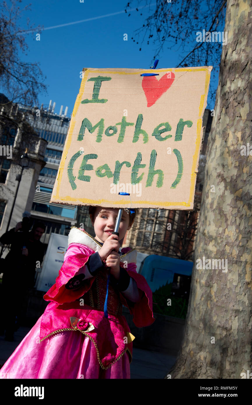 Londra, Regno Unito. 15 Feb, 2019. Migliaia di bambini in età scolare e giovani del Regno Unito hanno preso parte in clima di scioperi, passeggiate fuori della scuola per protestare contro l'inerzia del governo sul cambiamento climatico come parte di una campagna globale di azione sul cambiamento climatico.La scuola gli scioperi sono stati ispirati dal giovane attivista svedese Greta Thurnberg che dal mese di agosto 2018 è stata protestando il venerdì. A Londra migliaia di bambini e studenti si sono riuniti in piazza del Parlamento, Westminster. Una giovane ragazza tiene un home-messi a segno dicendo "Io amo la madre terra'. Credito: Jenny Matthews/Alamy Live News Foto Stock