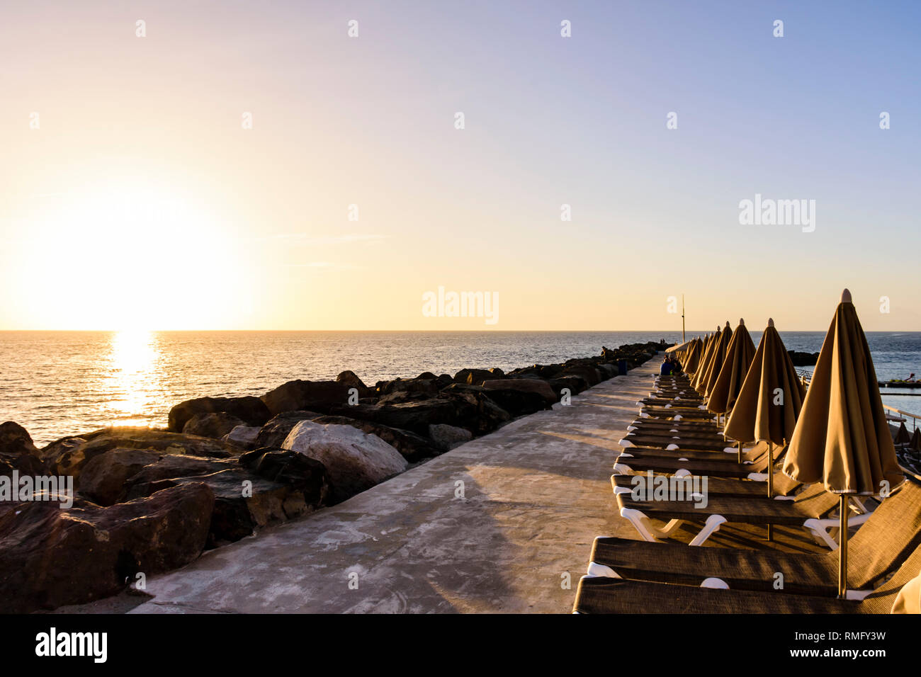 Ombrelloni contro il mare durante il tramonto in Amadadore, Gran Canaria, Spagna Foto Stock