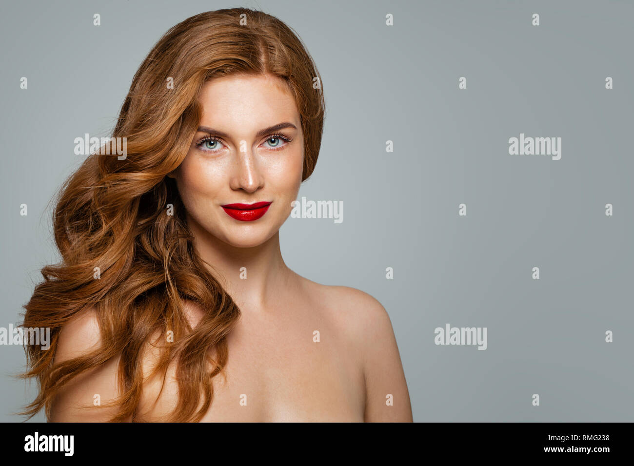Elegante donna con capelli rossi e labbra rosse del trucco. Pretty redhead ragazza con capelli ricci Foto Stock