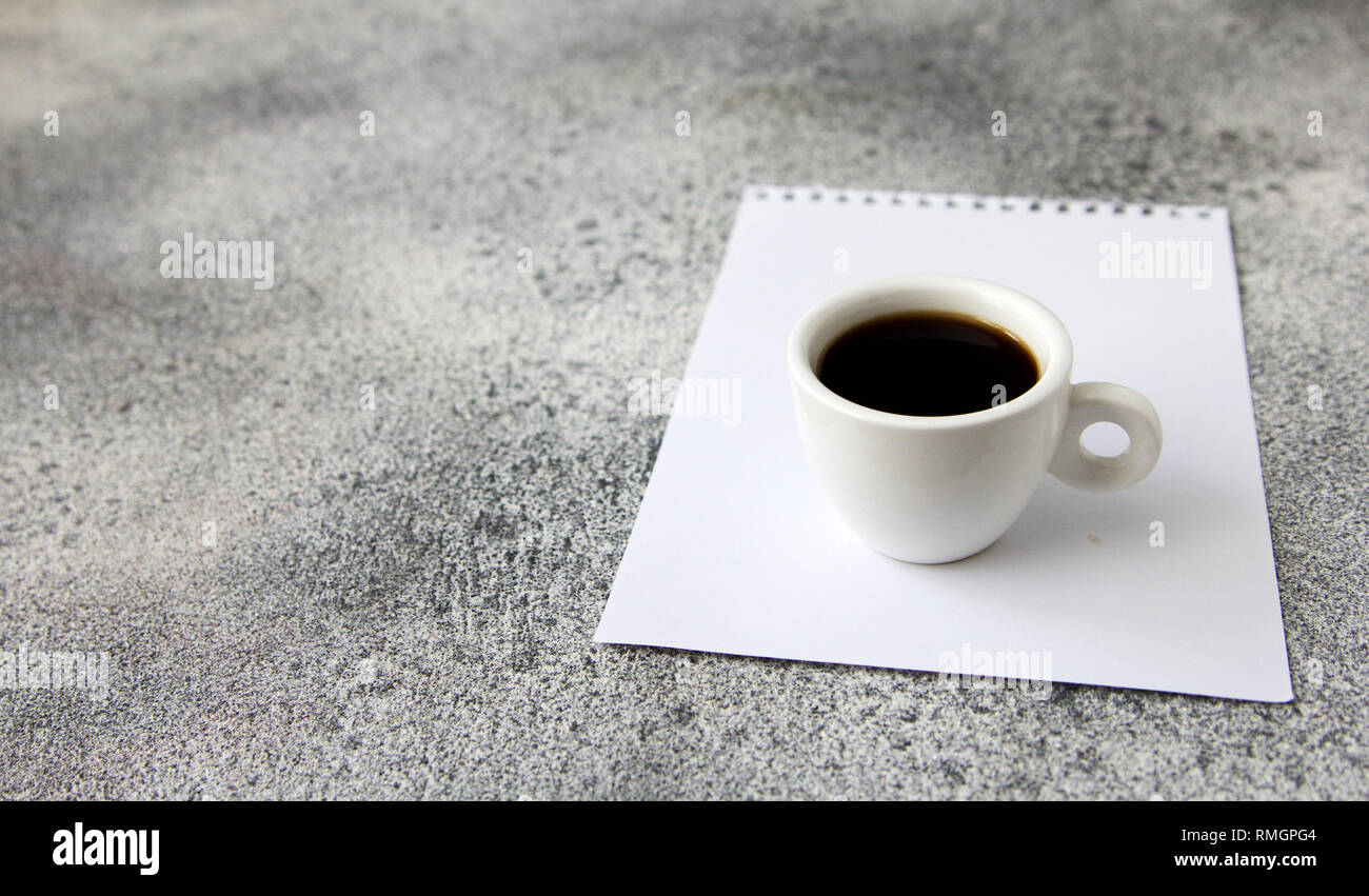 Сup del caffè e la carta su una tabella di calcestruzzo. Istruzione la concezione di business. Foto Stock