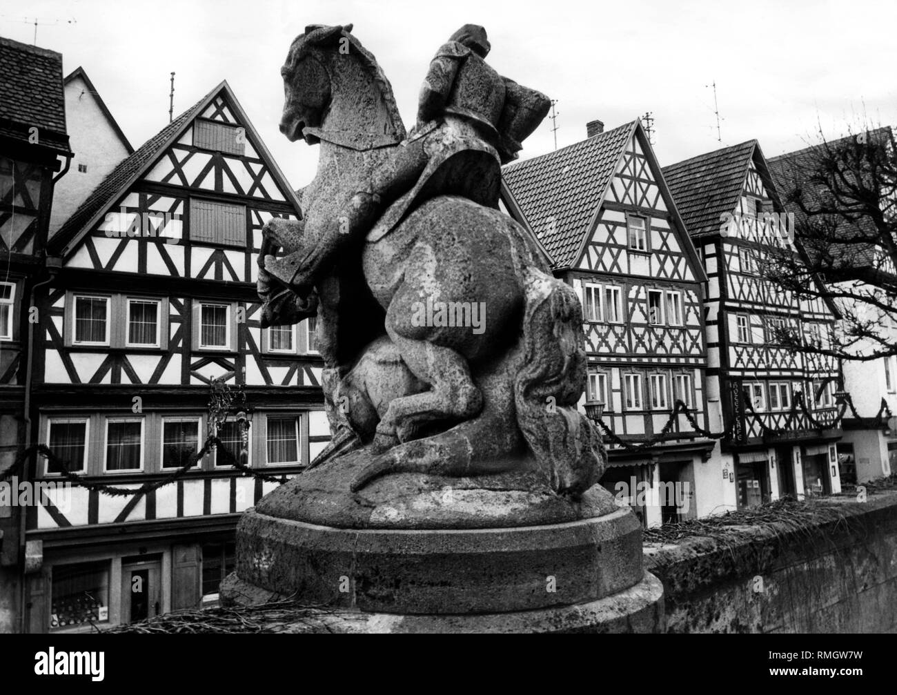 Vista di tipiche case a graticcio da San Andreas chiesa nella strada principale di Ochsenfurt. In primo piano, una statua equestre di un cavaliere. Foto non datata. Foto Stock