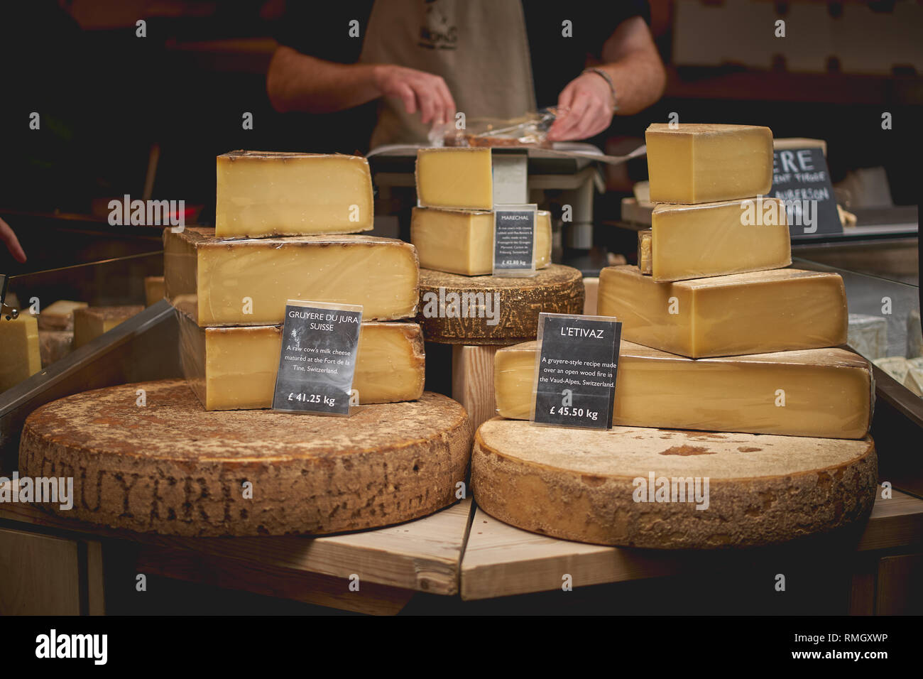 London, Regno Unito - Giugno, 2018. Svizzero di formaggio gruviera in vendita in una fase di stallo nel mercato di Borough, uno dei più antichi e più grande mercato alimentare a Londra. Foto Stock