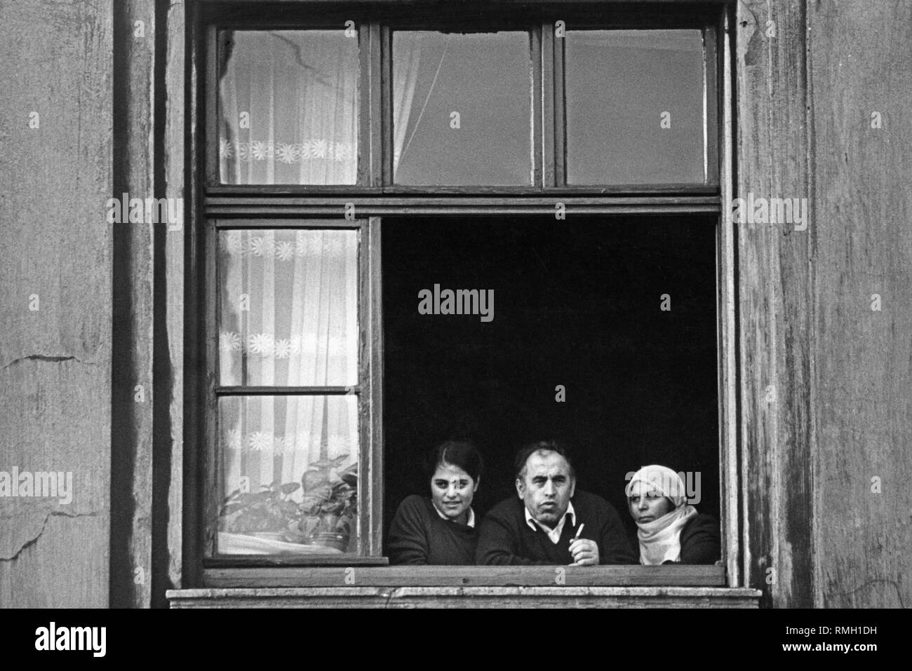 Una famiglia migrante in Duisburg-Hochfeld alla finestra del loro appartamento. Foto Stock