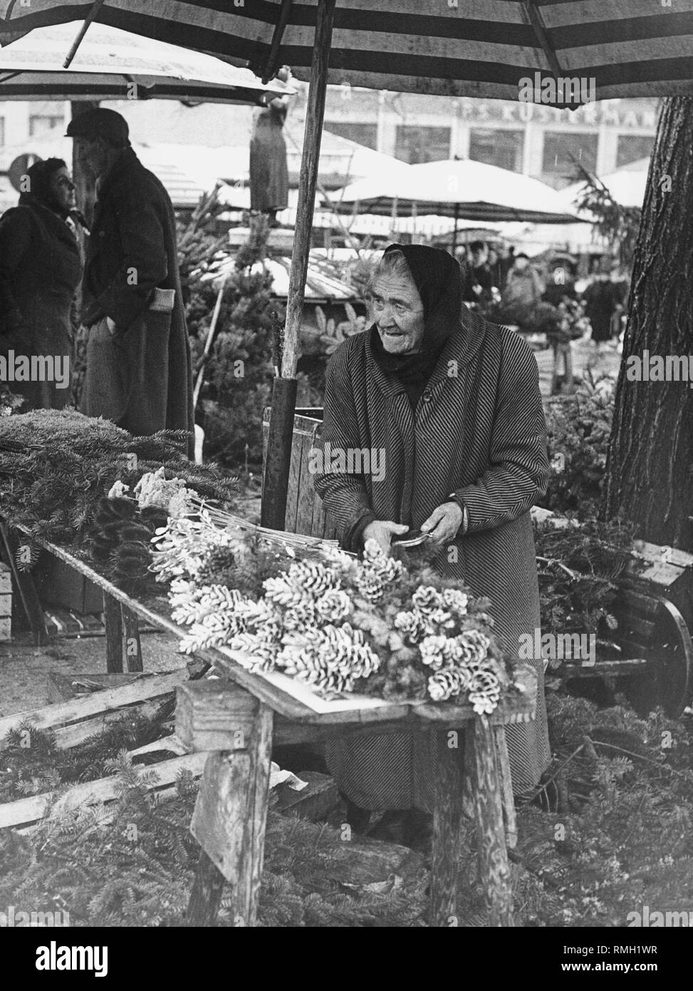 Stallo del mercato nel periodo pre-natalizio sul Viktualienmarkt in inverno 1961. Foto Stock