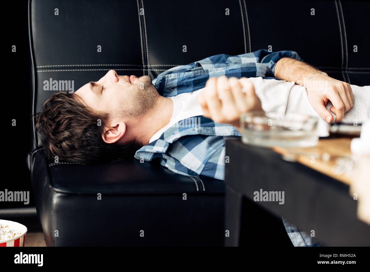 Messa a fuoco selettiva di stanco Uomo sdraiato sul divano e avente i postumi della sbornia Foto Stock
