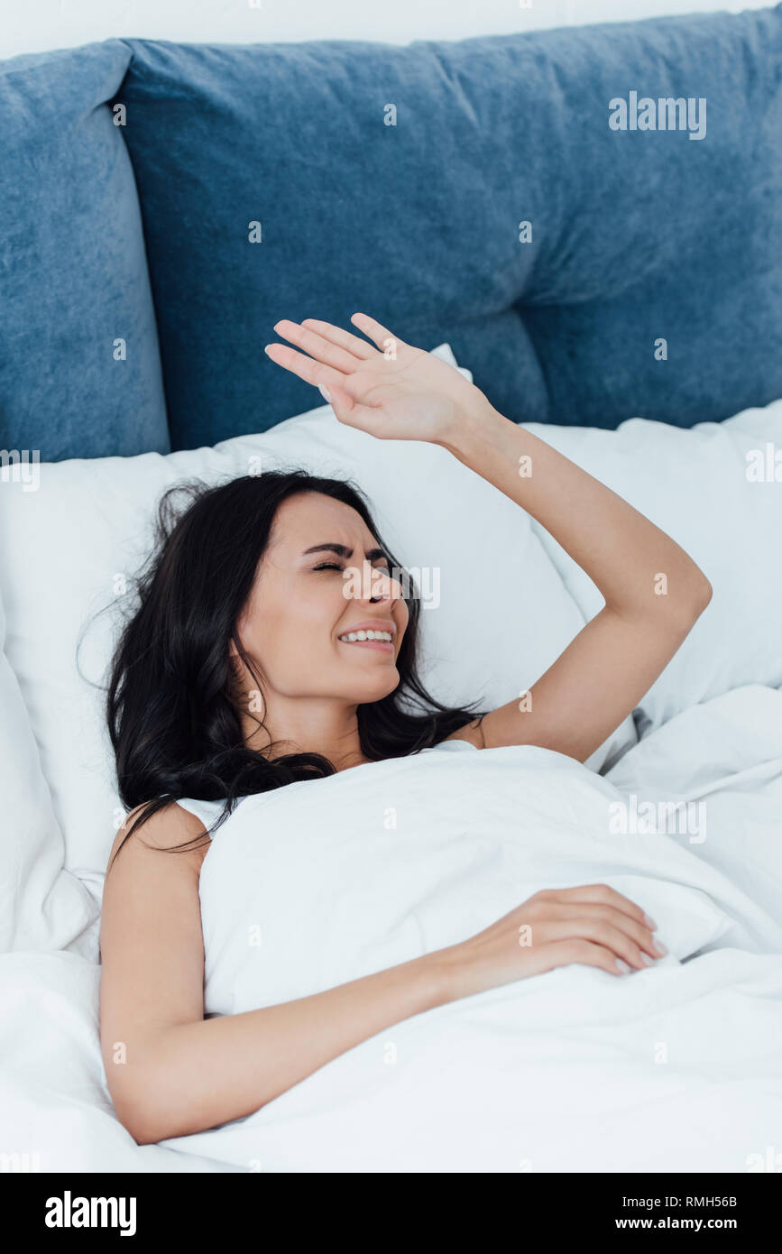 Insoddisfatto brunette donna giaceva a letto con gli occhi chiusi Foto Stock