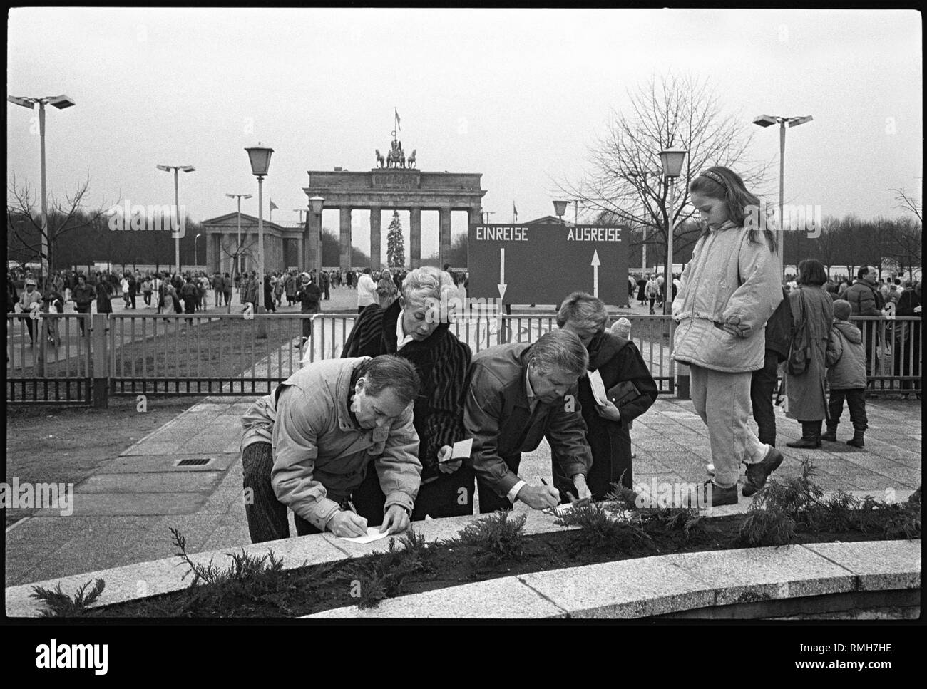 Dal 24 dicembre 1989, West tedeschi potrebbero travel visa-libero tra la RDT e la RFT dopo ardui negoziati di governo. Il minimo obbligo di scambio alla frontiera non era più necessaria. Migliaia di Berlino ai residenti e ai visitatori di utilizzare il nuovo regolamento di prendere un viaggio natalizio alla Porta di Brandeburgo. Il Pariser Platz è stato aperto al pubblico per la prima volta poiché il muro è stato costruito nel 1961. Qui i visitatori ad ovest sono la compilazione del cosiddetto Zaehlkarten, che sono ancora richiesti dalla RDT competenti ai fini del controllo. Foto Stock