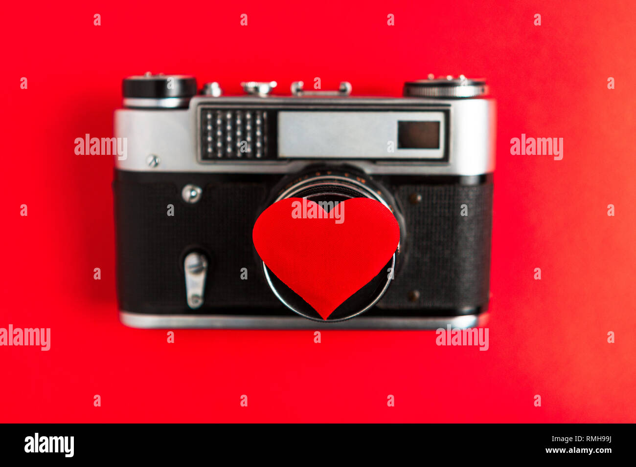 Vecchia foto vintage fotocamera con cuore rosso su di esso. sfondo rosso.per il decor e design. valentines greeting card. concetto amore e romanticismo in fotografie. Foto Stock