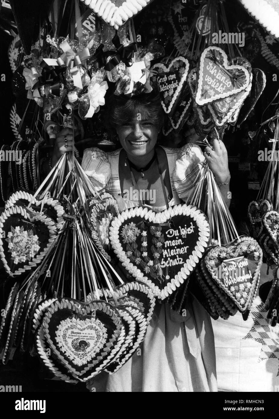 Donna vendita di panpepato cuori al Oktoberfest a Monaco di Baviera. Foto Stock