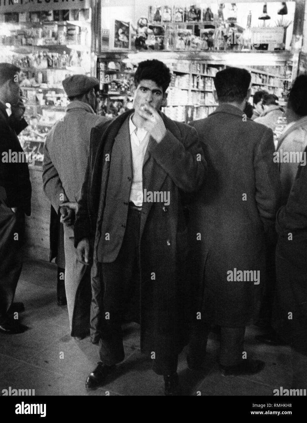 Un giovane italiano fuma in un ristorante in Italia prima di partire per la Germania. Foto Stock