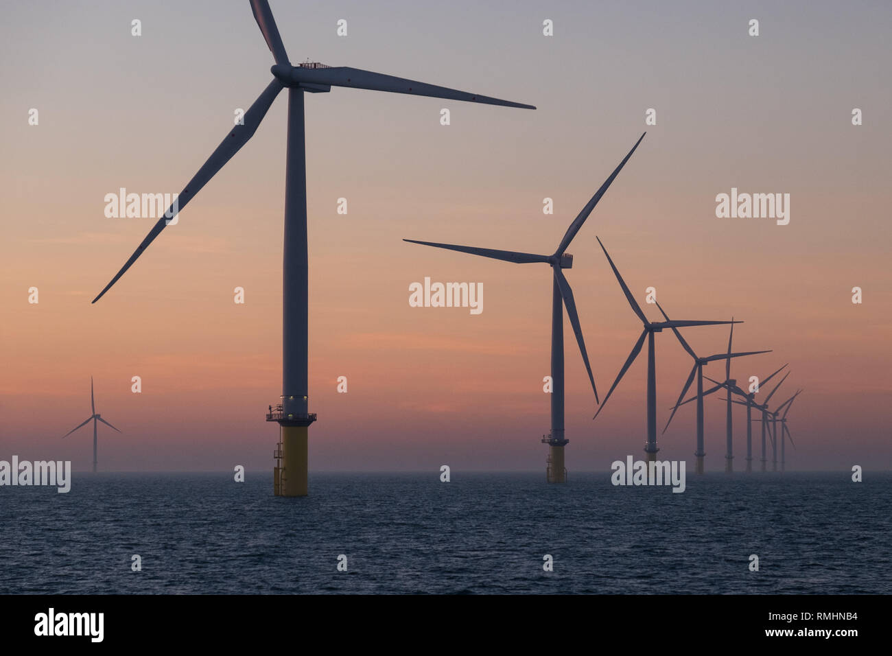 Le turbine eoliche sulla matrice di Londra Offshore Wind Farm in esterno di estuario del Tamigi durante il tramonto Foto Stock