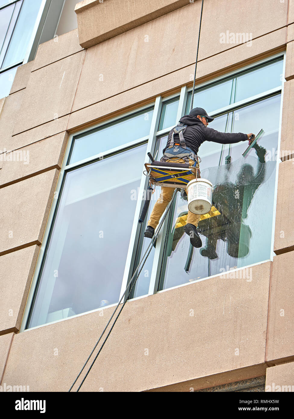 In prossimità di una finestra la rondella pulizia al di fuori delle finestre di un edificio alto a partire da un angolo basso, a Montgomery in Alabama, Stati Uniti d'America. Foto Stock
