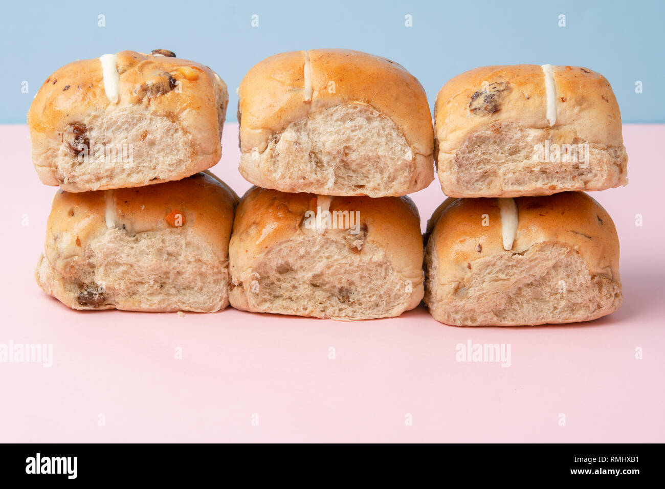 Sei hot cross panini, britannica tradizionale cibo Pasqua in rosa e sfondo blu, il fuoco selettivo Foto Stock