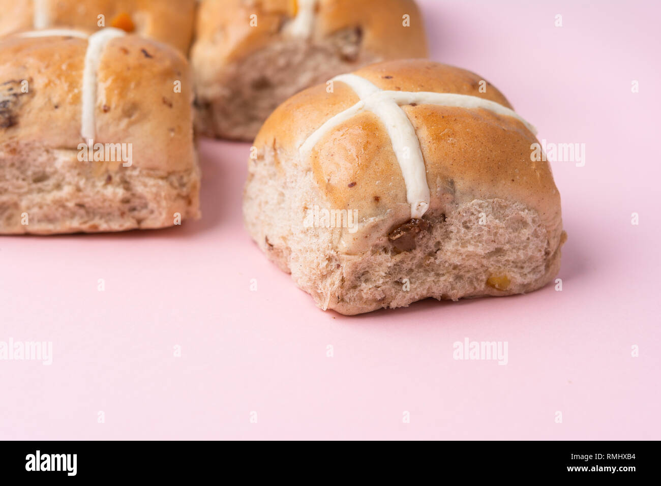 Hot cross panini, britannica tradizionale cibo Pasqua su sfondo rosa, il fuoco selettivo Foto Stock