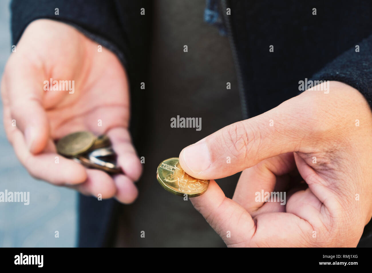 Primo piano di un giovane uomo caucasico su strada con alcuni Czech Koruna monete nelle sue mani Foto Stock