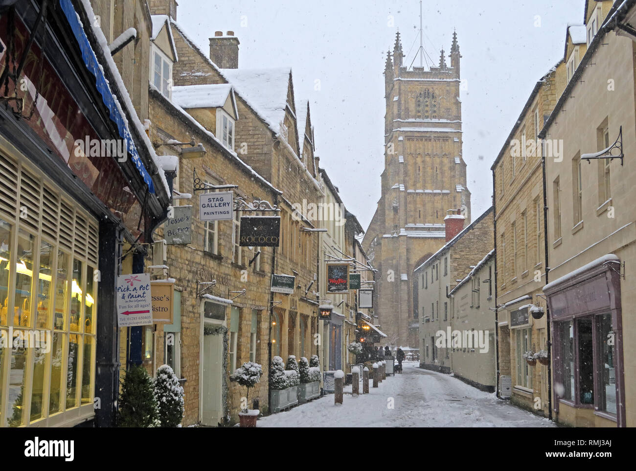 Visualizzare fino al Black Jack Street, Octavias Bookshop, alla chiesa di San Giovanni Battista, neve invernale Cirencester Town Center, Gloucestershire, Inghilterra, GL7 2AA Foto Stock
