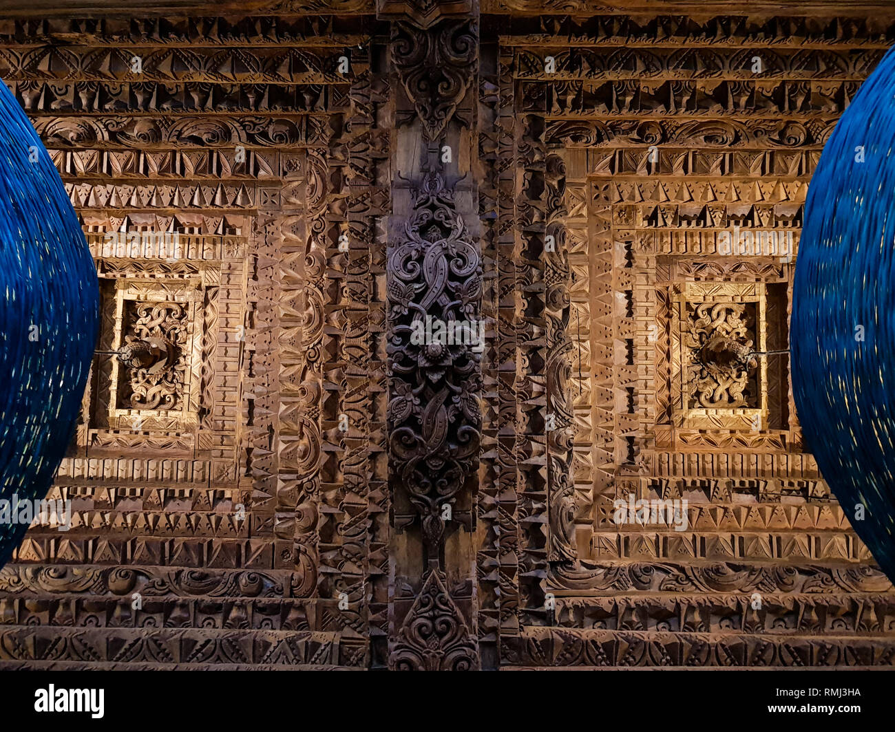 In legno scolpiti ornamento del soffitto sono illuminati da due fatti a mano di colore blu scuro lampade Foto Stock