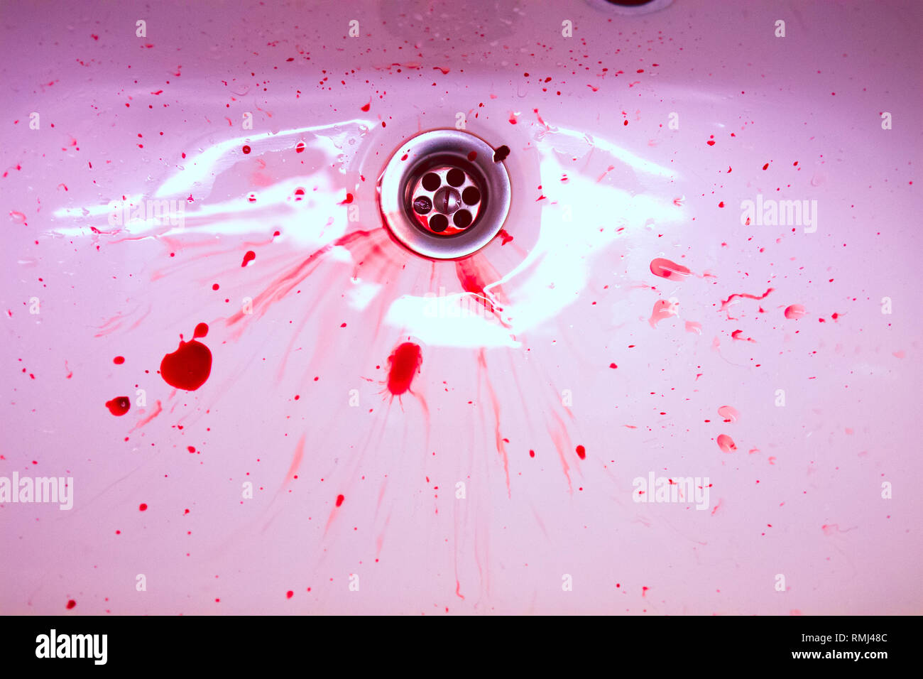 Bianco lavello in ceramica con il rosso delle macchie di sangue. Il concetto di sanguinosi suicidio e malattia Foto Stock