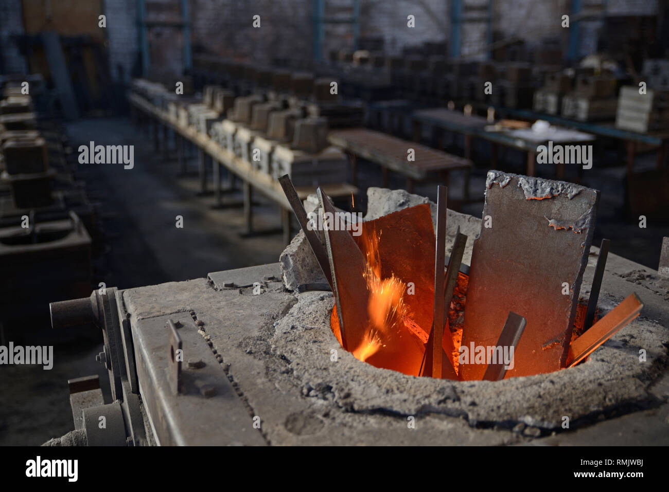 Le scintille volano come rottami di acciaio si fonde in un forno ad  induzione ad una piccola fonderia Foto stock - Alamy