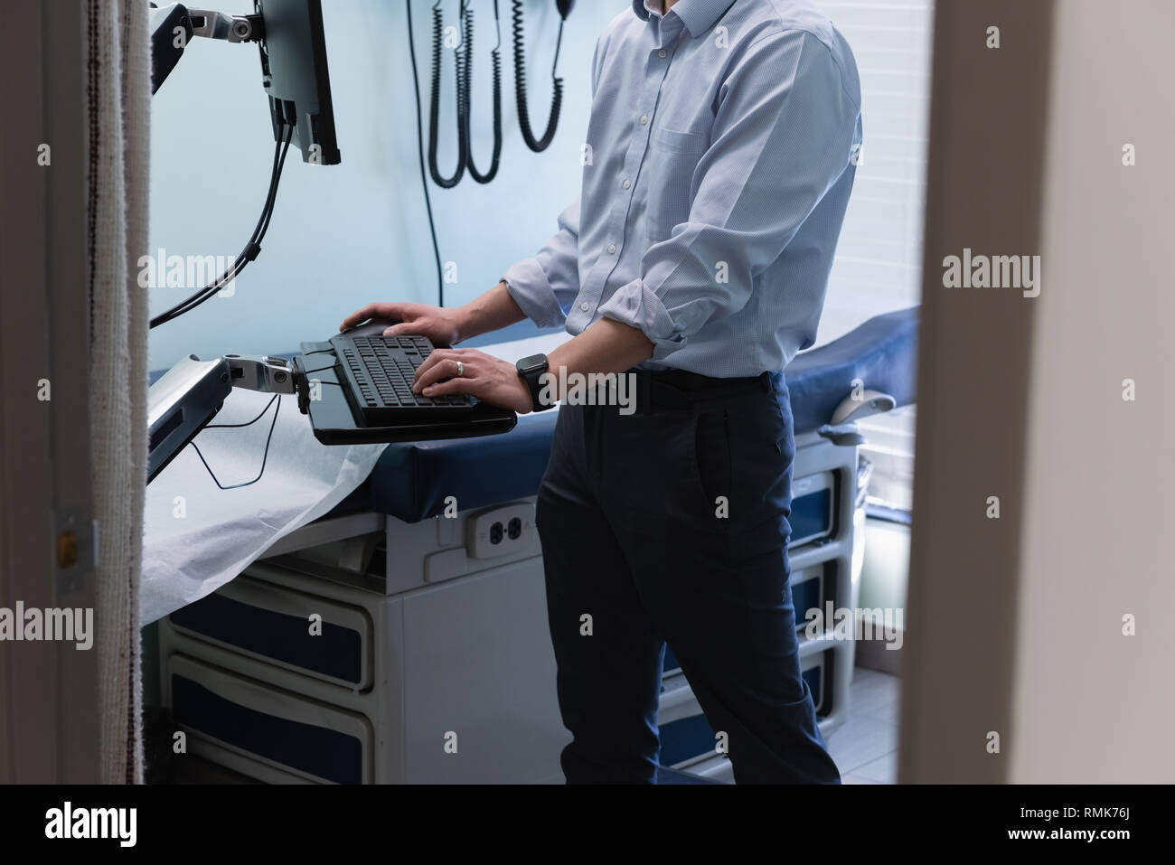 Giovani asiatici medico maschio lavora su computer in clinica Foto Stock