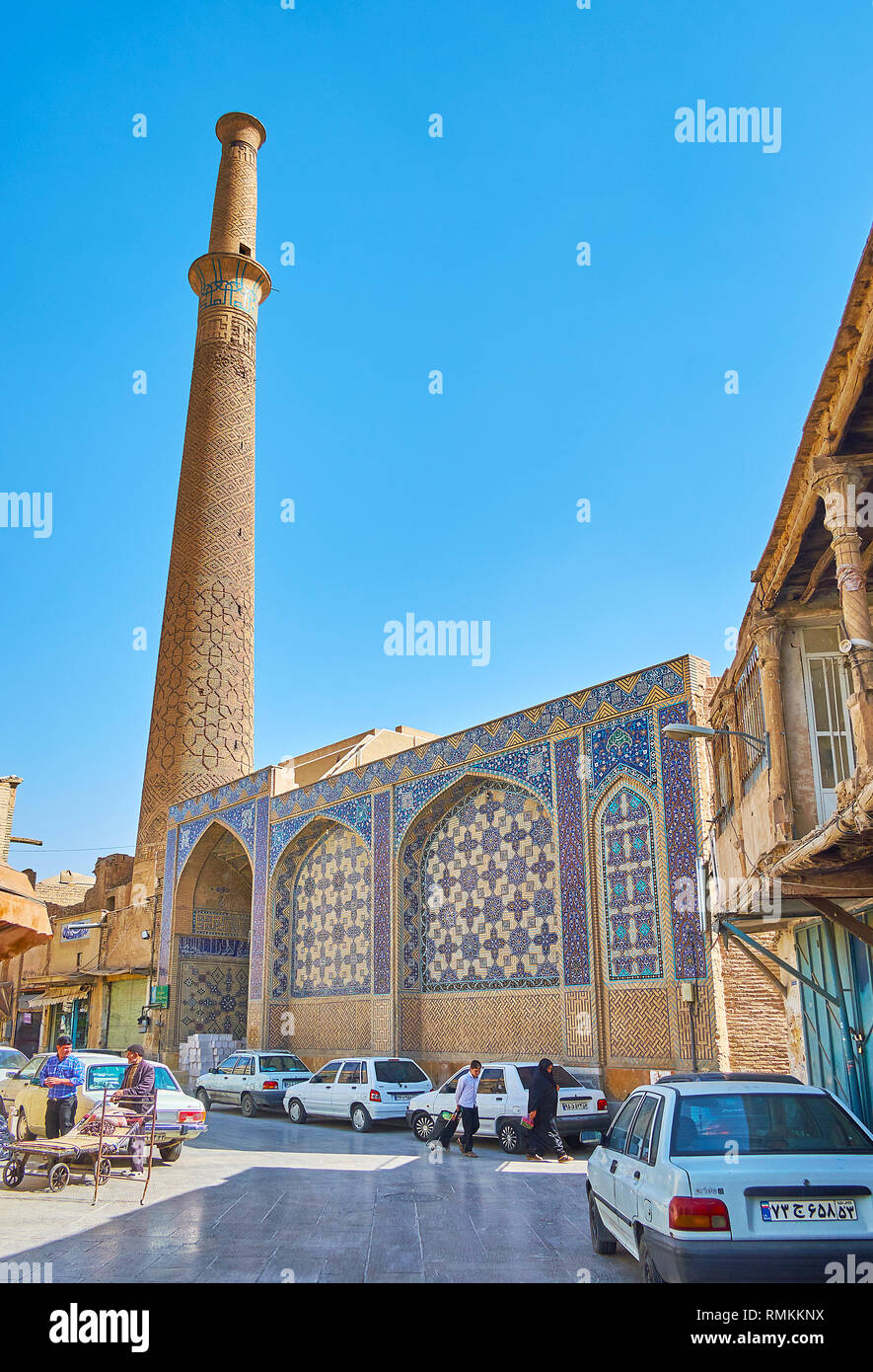 ISFAHAN, IRAN - 21 ottobre 2017: la facciata medievale della Imam Ali moschea con più alti in città minareto e scenic tiling si affaccia la stretta strada di Foto Stock