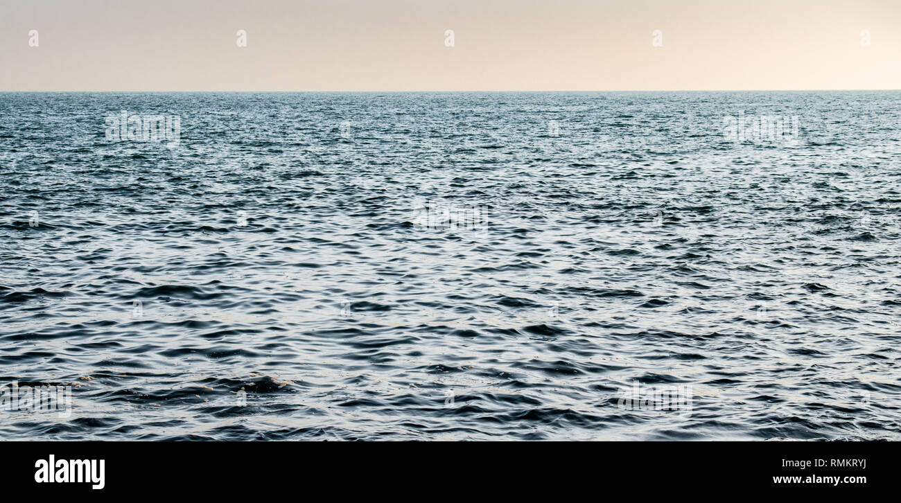 Bellissima foto di relativamente calma della superficie del mare (mare Arabico) con orizzonte chiaro subito dopo il tramonto. Tramonto dando una tinta magica per il colore dell'acqua. Foto Stock