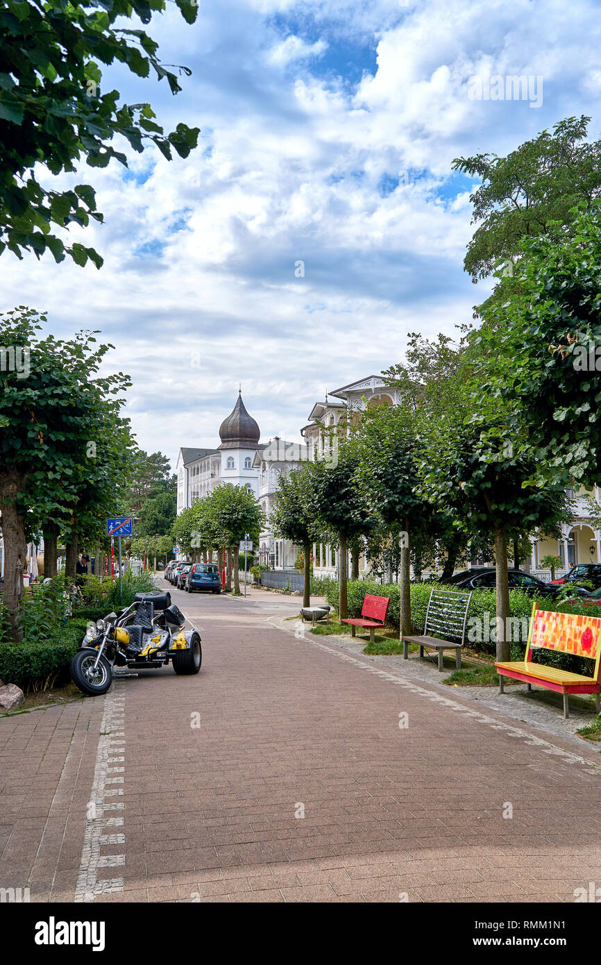 Banchi colorati e un motore trike nelle strade della città vecchia di Binz. Estate città sulla costa del Mar Baltico. Rügen è una popolare destinazione turistica Foto Stock