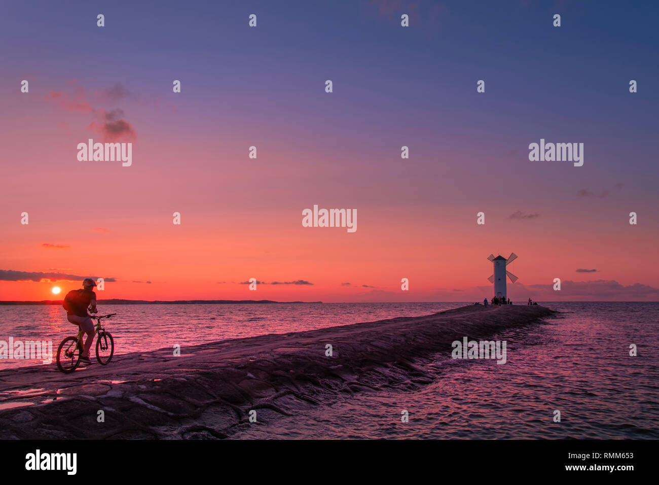 Ciclista al tramonto sulla spiaggia Foto Stock