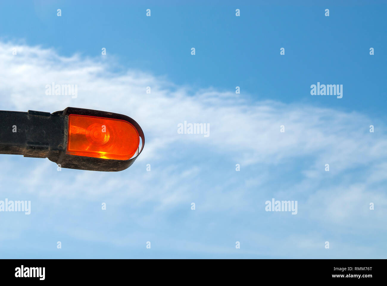 Arancione luce segnale contro il cielo blu Foto Stock