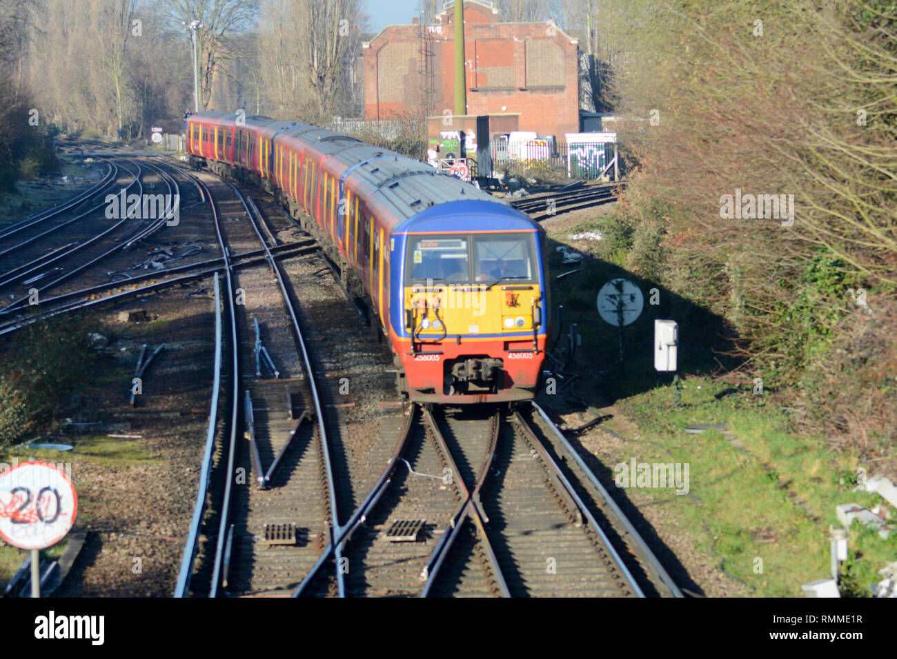 Le linee ferroviarie e treno in avvicinamento alla stazione di Barnes, London, SW13, Regno Unito Foto Stock