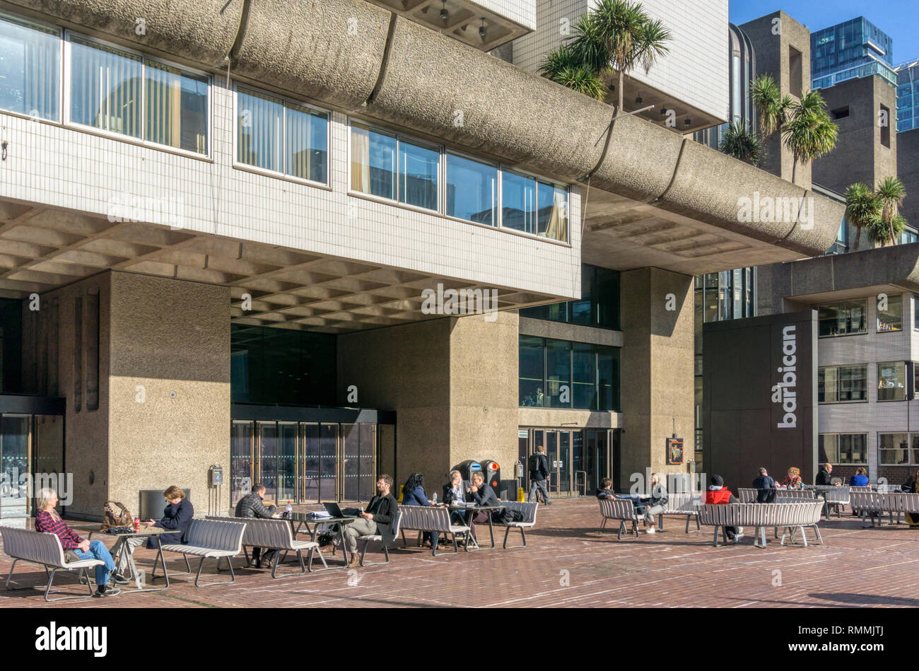 La gente seduta al di fuori del Barbican Arts Centre di Londra. Foto Stock