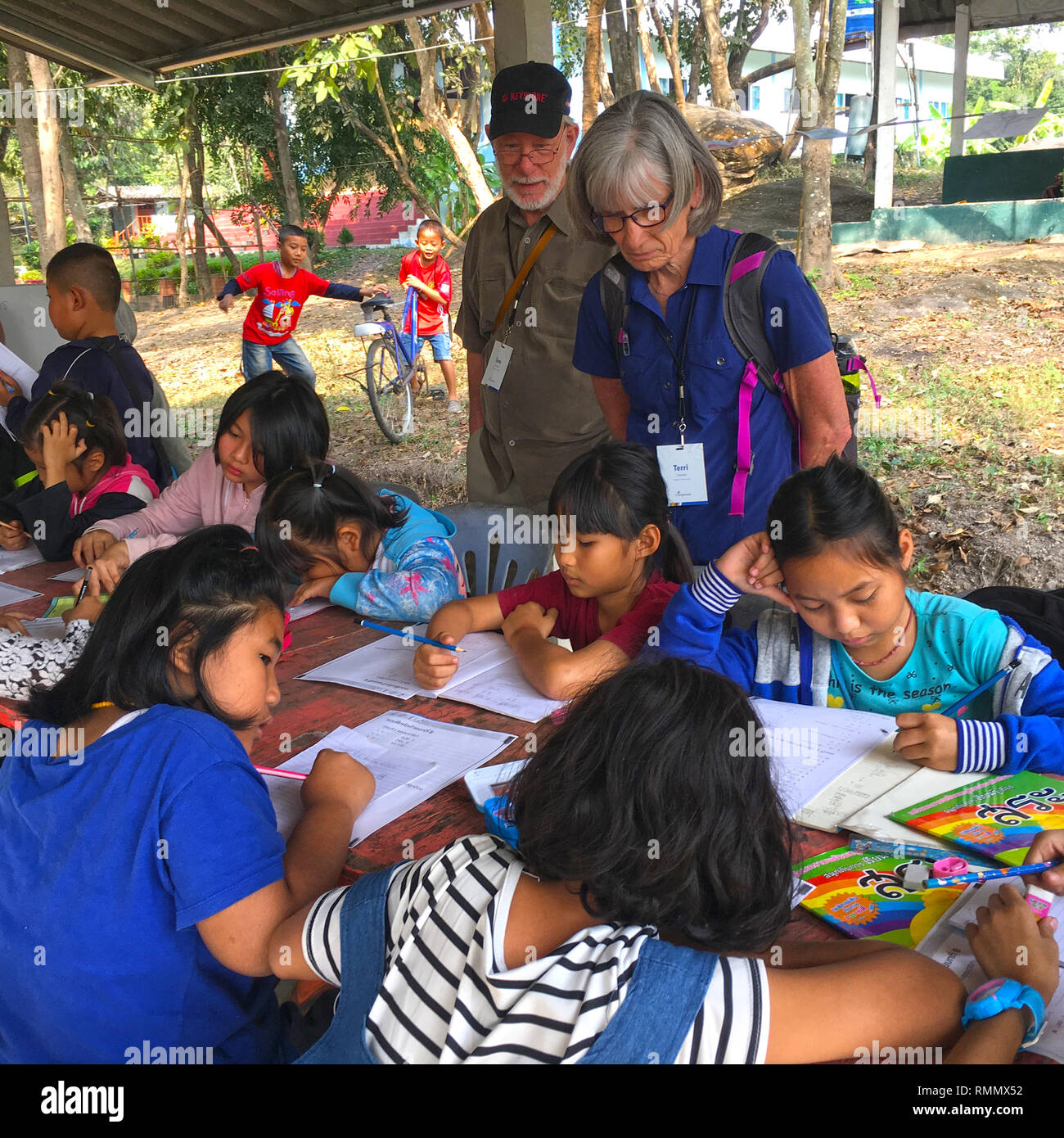 Coppia caucasica osservando i bambini in una classe tailandese Foto Stock