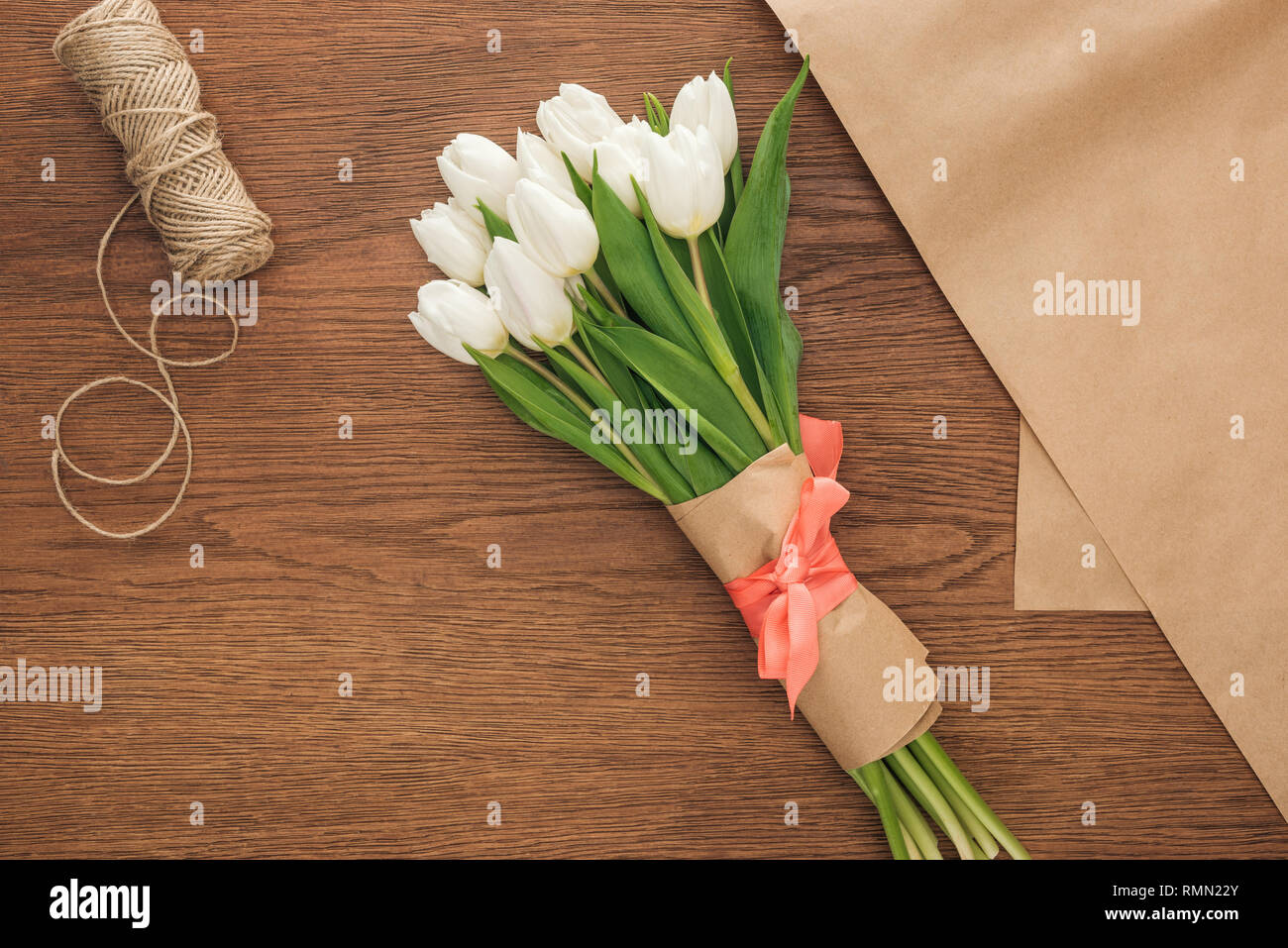 Vista superiore della molla tulip bouquet e imbarcazioni carta su sfondo di legno Foto Stock